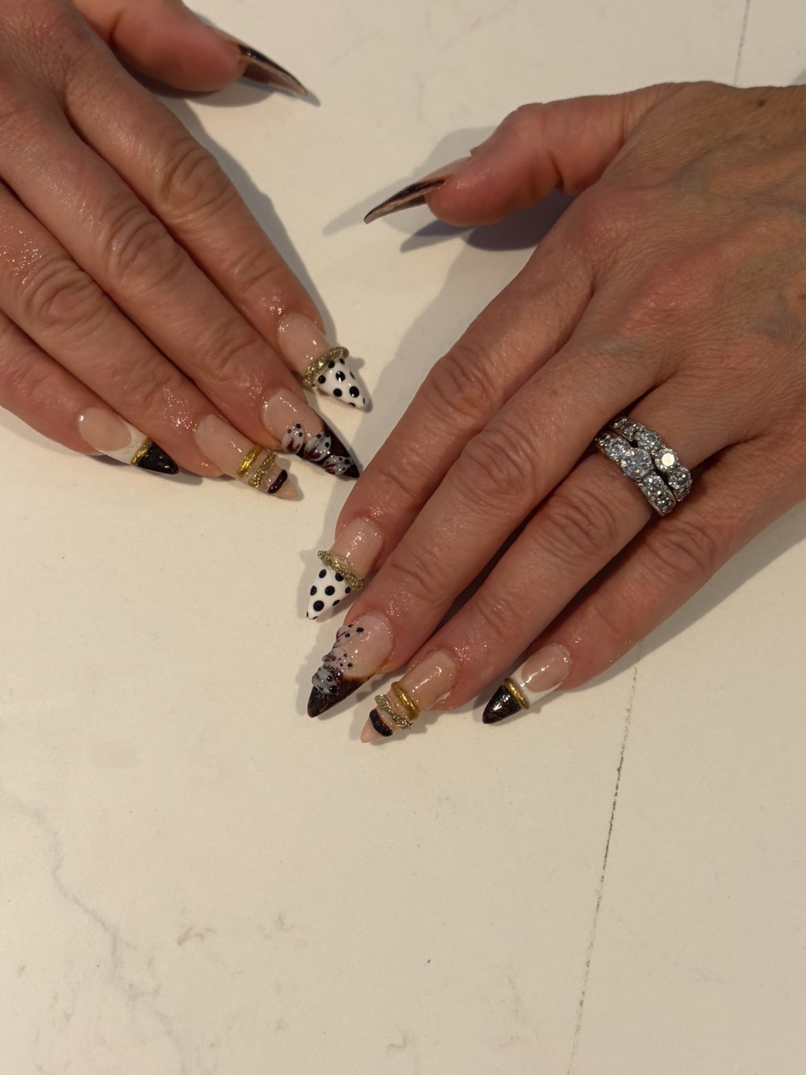 Black and white polka dot nails with gold chrome rings